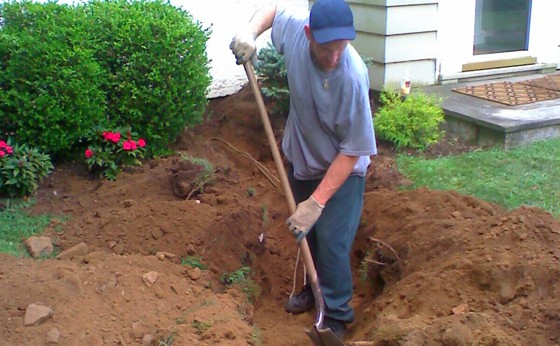 Digging to uncover tank by hand as to not disturb gas lines